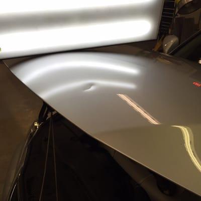 A Lexus with a gouged out dent in an aluminum hood, repaired with out any filler and perfectly spot painted to finish.