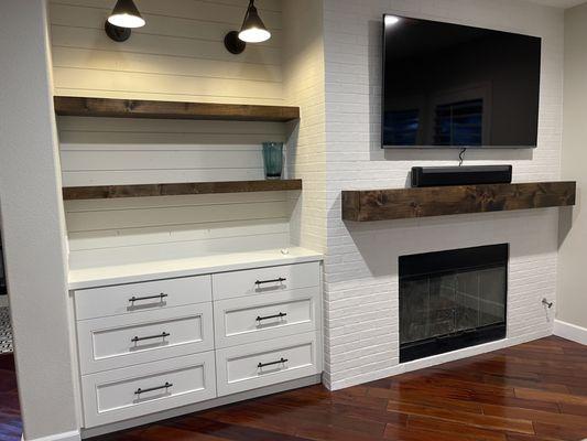 Custom stained mantle, floating shelves and painted custom cabinet with wood top and soft close dovetail drawers.