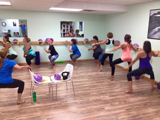 Group Barre exercise class at Revitalize Physical Therapy working on strengthening the legs, butt and core.