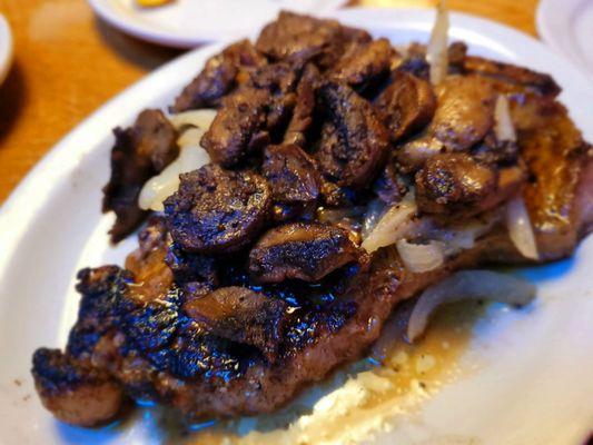 Porterhouse topped with grilled mushrooms and onions