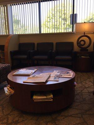 Waiting room with comfortable seating and lots of magazines. There's also a TV in the corner.