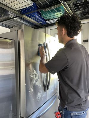 Enrique wiping down the fridge before they left.