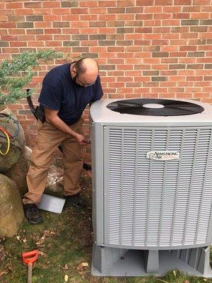 Owner Mike installing a new high efficiency air conditioning unit.