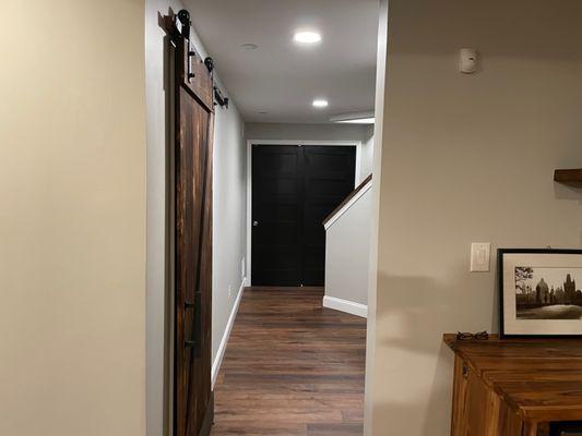 Hallway leading to large room with Barn Door and sliding two panel black doors