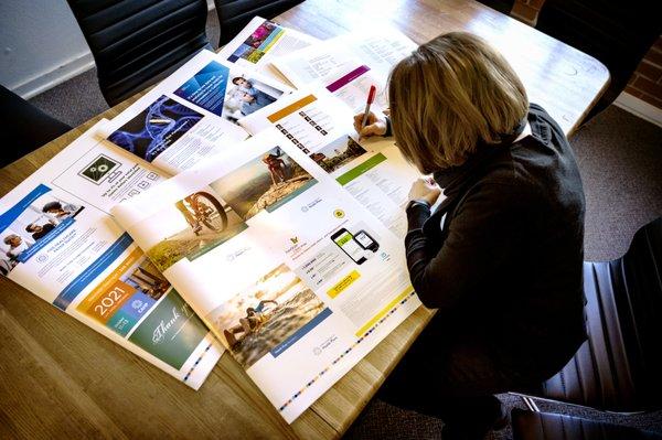 Production Manager Sherril reviewing client proofs