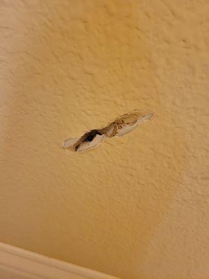 One of the holes in drywall made when the mirror fell