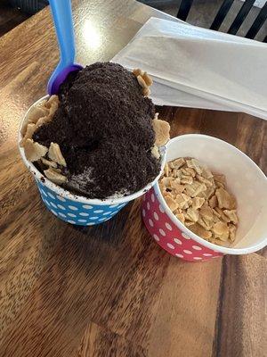 Two scoops of cookies n cream topped with Oreo dust and waffle cone pieces.