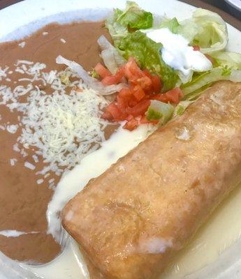 Beef Chimichanga with Mexican cream, beans, lettuce, tomato, guacamole. Delicious!