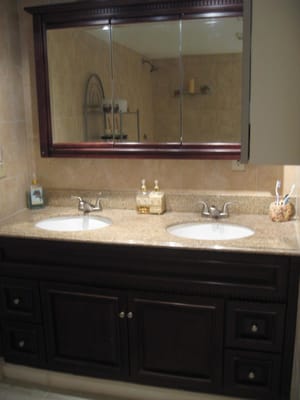 residential granite counter top with double porcelain sinks and two-handled nickel brushed faucets