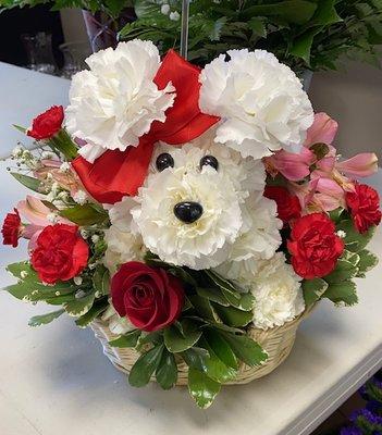 Puppy made of white carnation flowers in a basket