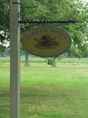 museum sign hanging from tree