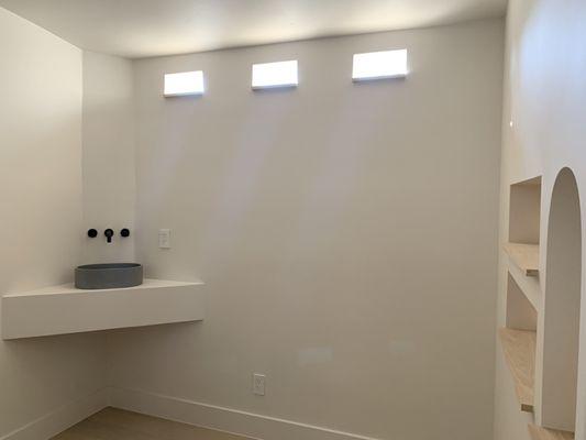 New room finish out with drywall, paint, sink, flooring, custom recessed shelving, and custom windows.