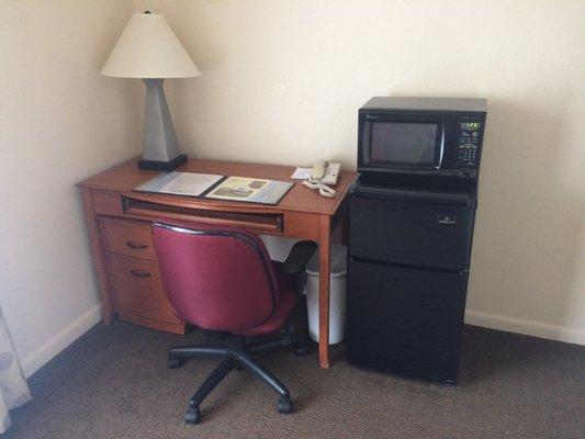 Desk with small refrigerator and microwave