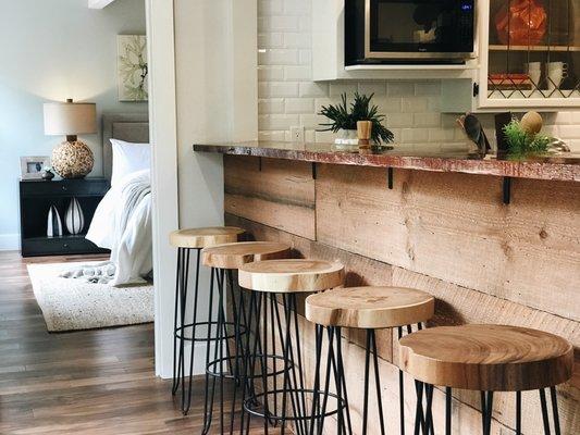 Great organic bar stools highlight the beautiful reclaimed wood wall