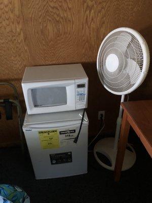 Microwave, mini fridge and portable fan,  air conditioner (not shown)