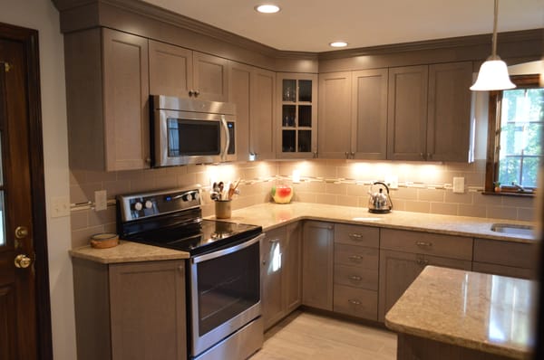 Custom cabinetry, quartz countertops and new tile plank flooring in Mansfield, MA installed and designed by Attleboro Kitchen and Bath