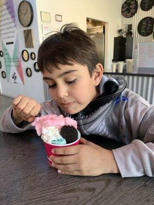 Cotton candy rolled ice cream with Oreos and whipped cream.