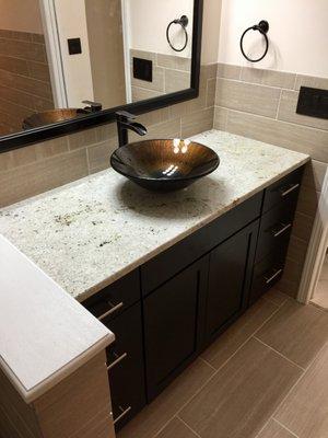 Completed master bathroom project in a Northville finished basement.  Espresso cabinets, ceramic wall & floor tile and vessel sink.