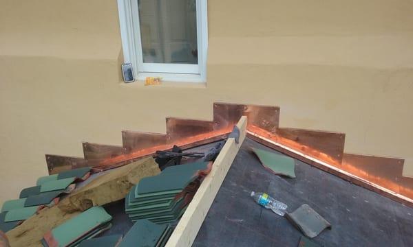 COPPER STEP FLASHING TURNED INTO STUCCO WALL.