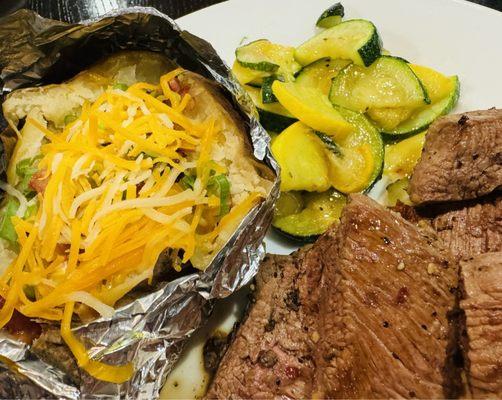 Bite Size Steak with loaded potato, & summer veggies.