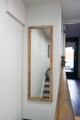 Tall mirror mounted over stairs