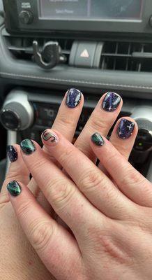 One set is galaxy on dip powder, the other set is dinosaur themed on dip powder