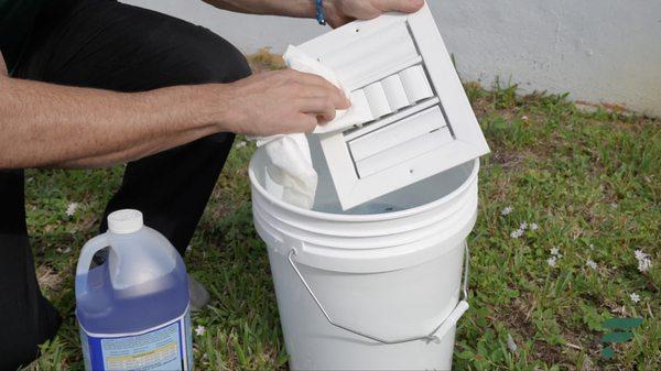 A Filterbuy LOCAL technician cleaning and sanitizing the ductwork registers and grilles for a Florida client.