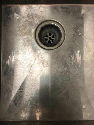 Scratched kitchen sink with grout