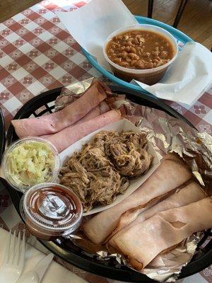 Bbq sampler with sliced smoked turkey and ham, pulled pork and a side of pinto beans.