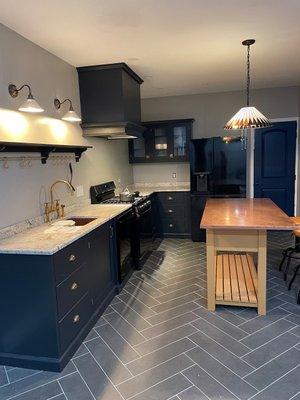 Ardmore Kitchen with navy blue inset doors. The furniture piece island and herringbone tile work set this kitchen remodel apart!