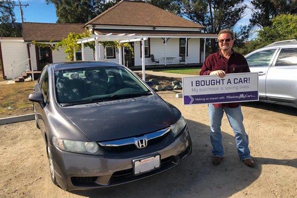 Happy customer purchasing a car on our property.