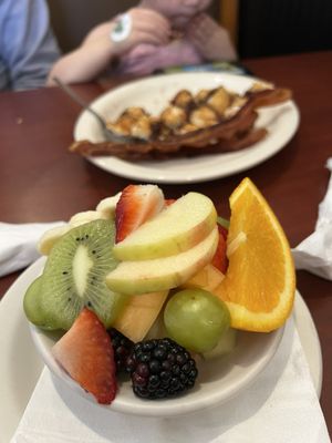 Fruit salad, with chocolate chip pancakes and crispy bacon