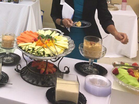 Vegetables and hummus for healthy simple reception. Coffee and hot cider in the back on right and bar on left.