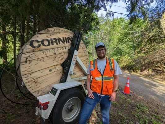 Our founder standing next to a spool of 4 miles of 288 count fiber cable