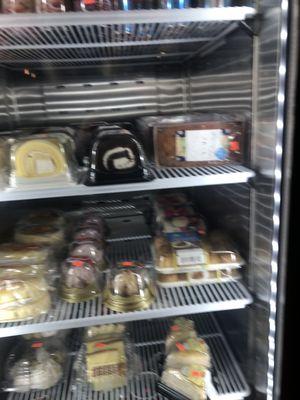 Desserts, cake slices in fridge.