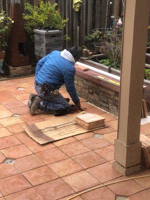 Cutting and setting edge tiles including cutting and aligning small drainage holes thru the stone wall and bench