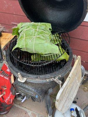 Smoked pork butt wrapped in banana leaves