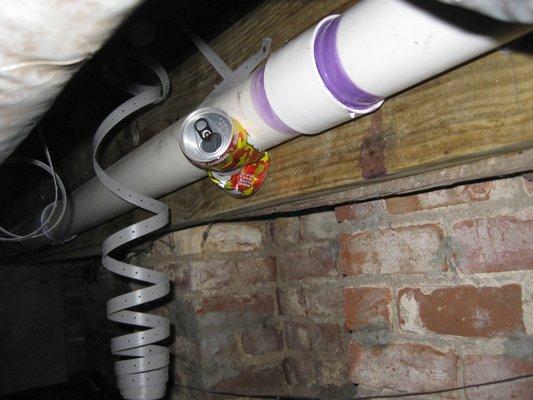 Eddy Bittner recycling his on the job drinks cans to hold up the plumbing.