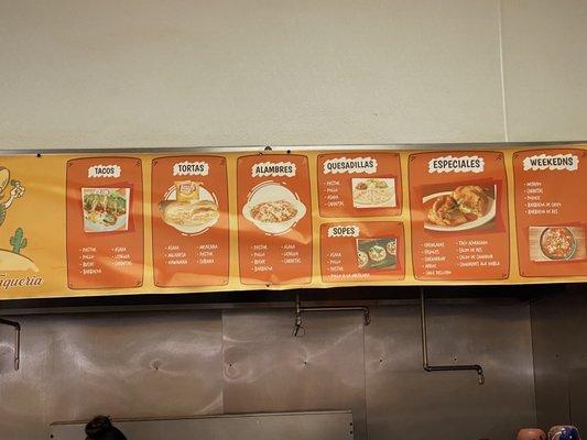 Menu of taqueria at back of store