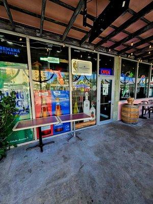 Entrance and patio area. There is one door to enter, and another door/wall separating the liquor store from the bar lounge.