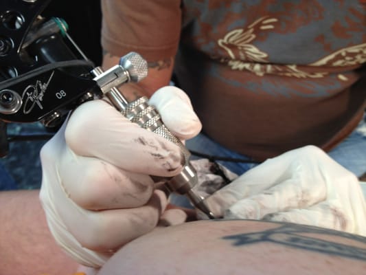 Owner/Artist Ron doing some work around an existing tattoo