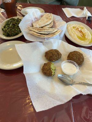 Appetizers of tabouleh, hummus and falafel, served with warm pita bread