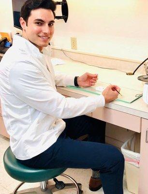 Dr. Connor Malek working hard glazing a ceramic crown to be fired in dental furnace heating lab. iSmileSpa offers same day crowns!