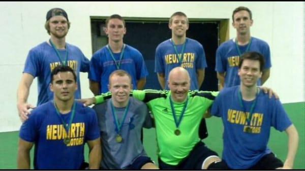 Team photo with wall and goal in the back ground