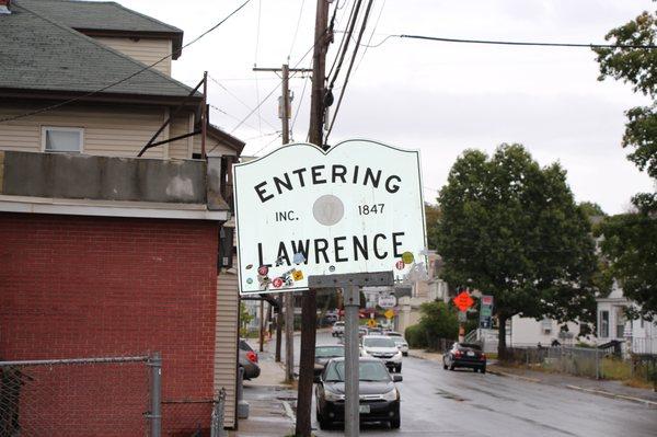 A Lawrence sign with a bunch of Stickers. This is at the Methuen line.