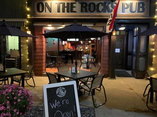 Street view of On the Rocks Pub, outdoor seating as well as open doors!