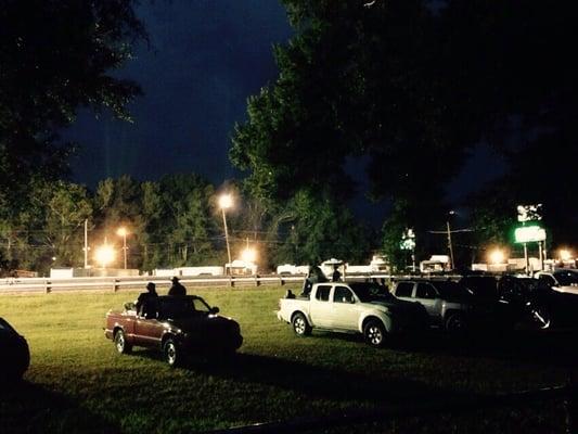 Drag racing at night with lightning in back ground