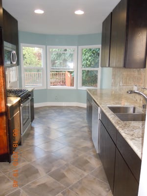 Oak vaneer cabinets, 16 x 16 tile floors, paint, new appliances and granite countertops.