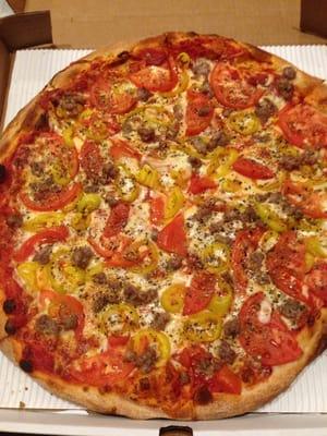 Large pizza with tomatoes, yellow peppers and sausage!