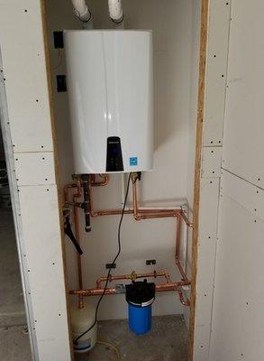 Navien tankless water heater with hot water recirculation, a thermal expansion tank, and a polyphosphate filter.